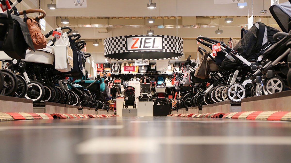 Photo of a babymarkt store floor showing a line of various baby carriages for sale